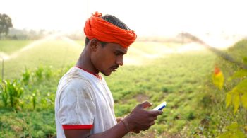 indian-famer-using-mobile-at-green-chickpea-field-2021-12-09-02-29-51-utc