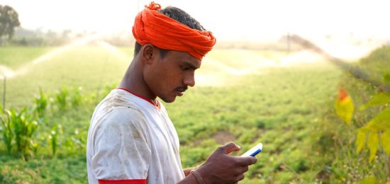 indian-famer-using-mobile-at-green-chickpea-field-2021-12-09-02-29-51-utc
